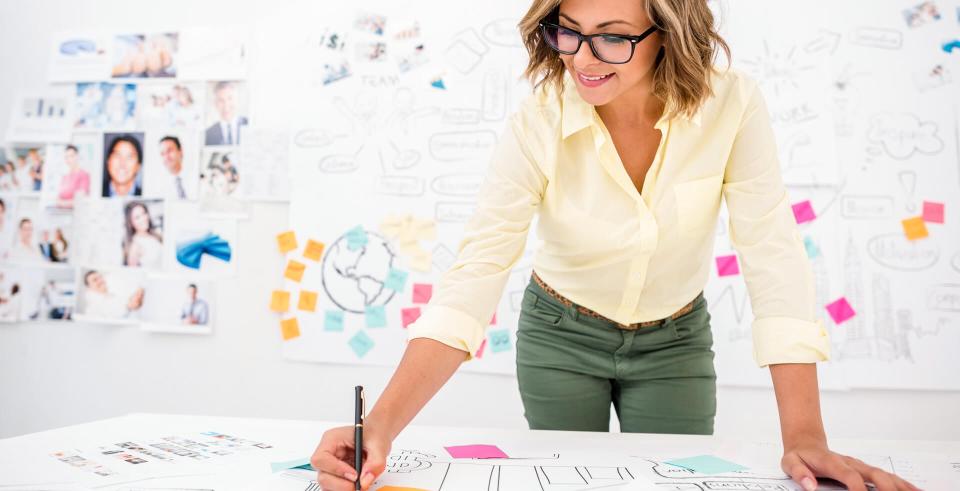 Woman in her 20s drawing a creative business plan at the office.