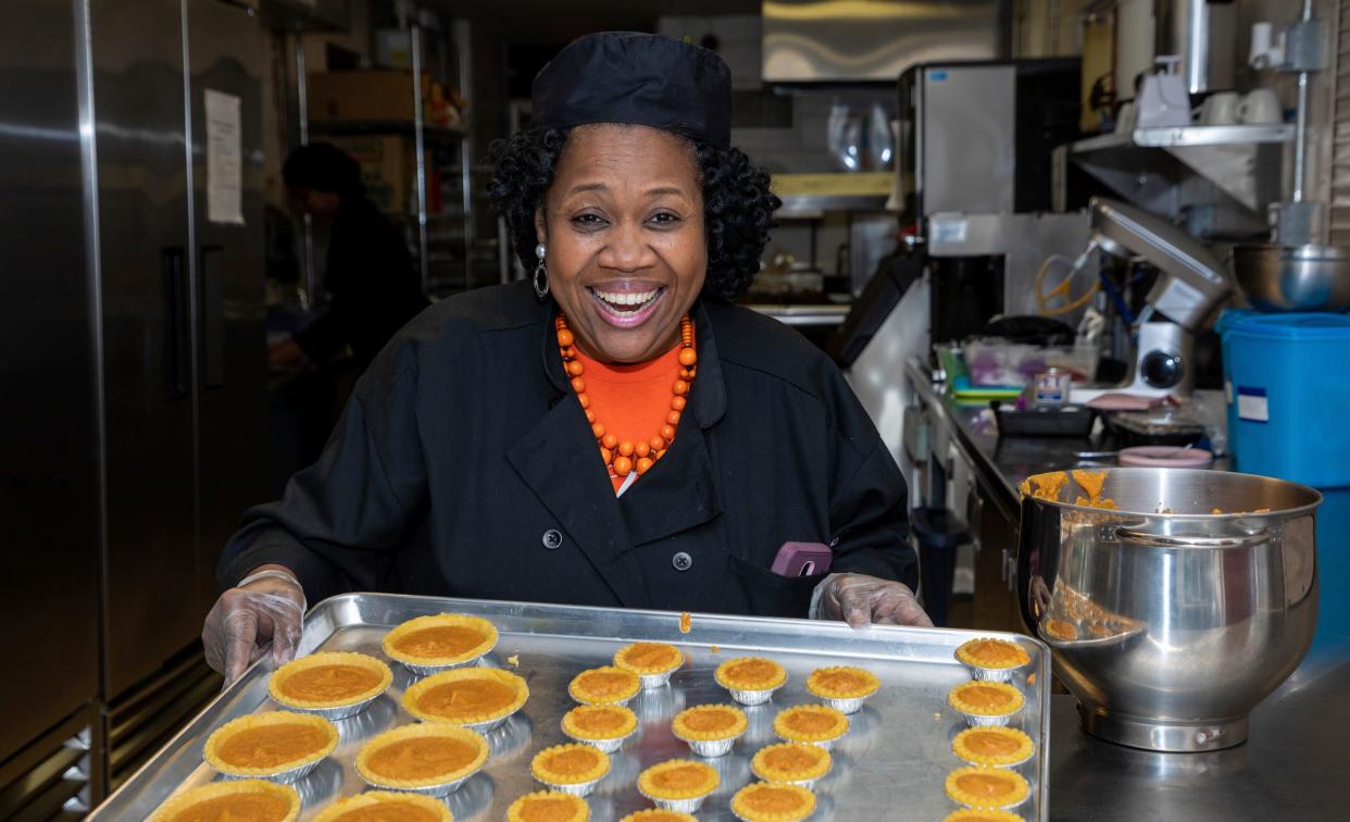 Linda Smith-Cummings, the owner of Soul Amazing LLC, holds a tray full of sweet potato pies inside the North Rosedale Park Community House kitchen in Detroit on Wednesday, Nov. 16, 2022. 