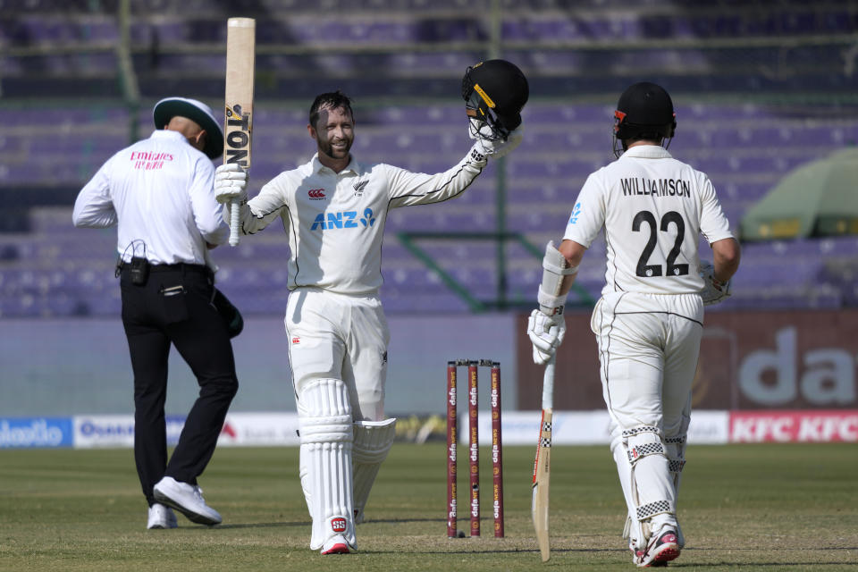 New Zealand's Devon Conway, center, celebrates after scoring 100 runs during the first day of the second test cricket match between Pakistan and New Zealand, in Karachi, Pakistan, Monday, Jan. 2, 2023. (AP Photo/Fareed Khan)