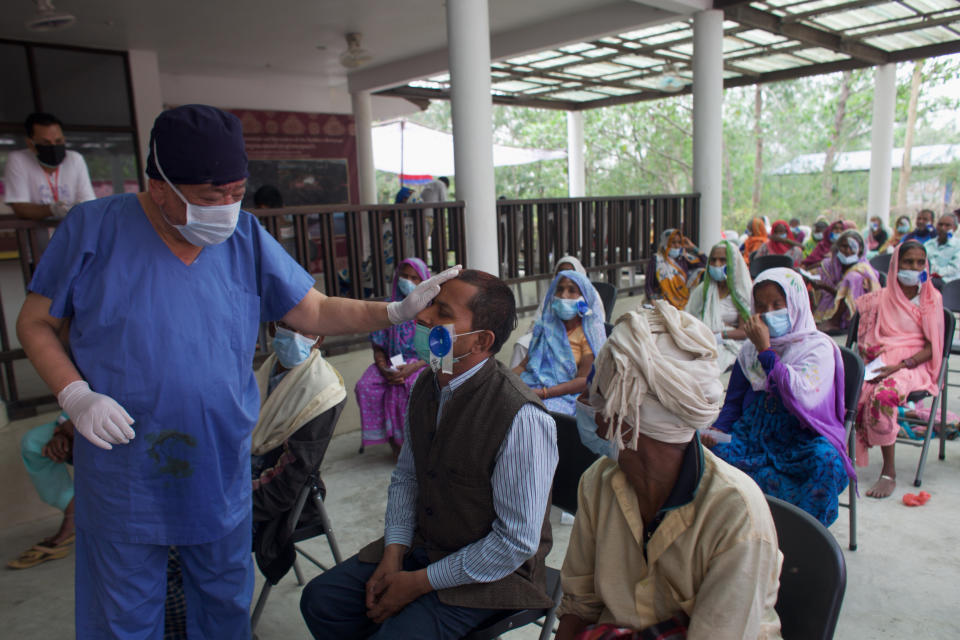 Nepal’s “God of Sight”, Dr. Sanduk Ruit checks a patient's eye sight after his eye patches are removed at an eye camp in Lumbini, 288 kilometers (180 miles) south west of Kathmandu, Nepal, March 31, 2021. The eye doctor renowned for his innovative and inexpensive cataract surgery for the poor is taking his work beyond the Himalayan mountains to other parts of the world so there is no more unnecessary blindness in the world. Ruit, who has won many awards for his work and performed some 130,000 cataract surgery in the past three decades, is aiming to expand his work beyond the borders of his home country and the region to go globally. (AP Photo/Bikram Rai)