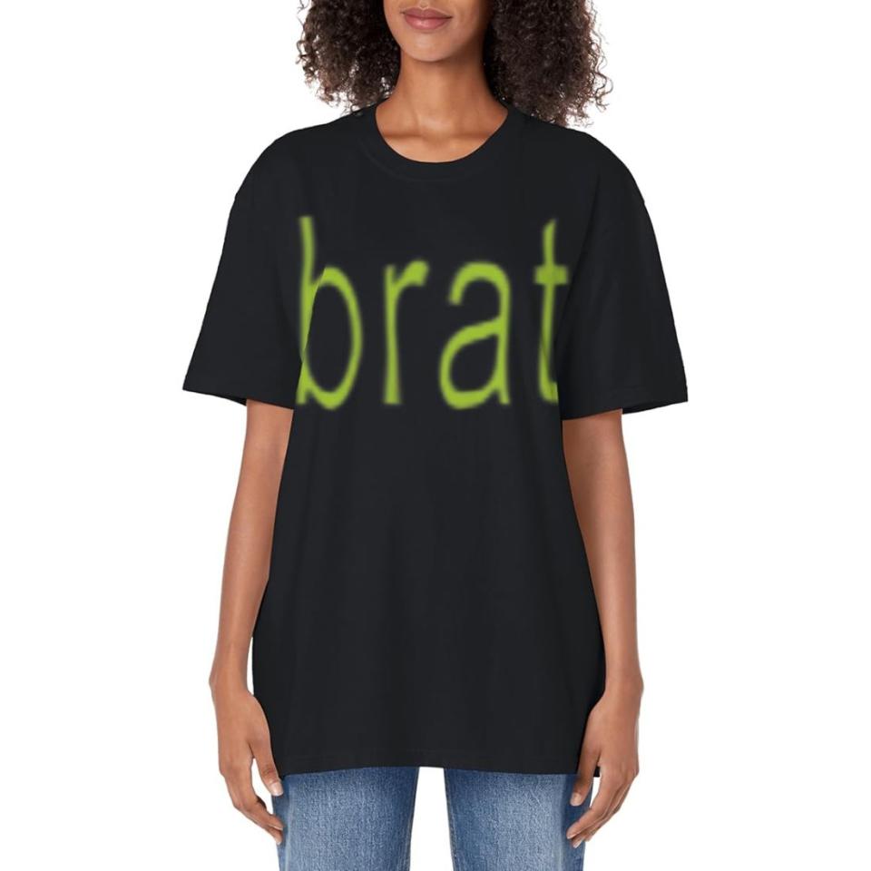 model wearing a black t-shirt with green brat text and jeans