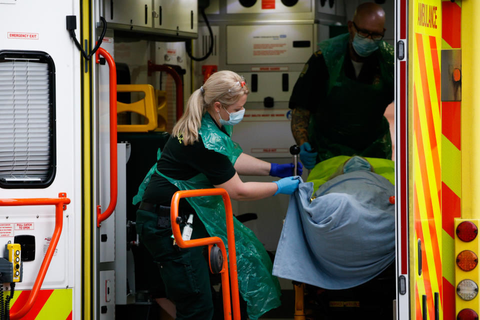 Paramedics prepare to lower a patient from an ambulance outside the emergency department of the Royal London Hospital in London, England, on January 26, 2021. Data from the UK's official statistics bodies revealed today that, based on death certificates, up to January 15 this year nearly 104,000 people have died with coronavirus since the pandemic began. Government figures, which are based on deaths within 28 days of a positive covid-19 test, remain slightly lower, yesterday standing at 98,531. (Photo by David Cliff/NurPhoto via Getty Images)