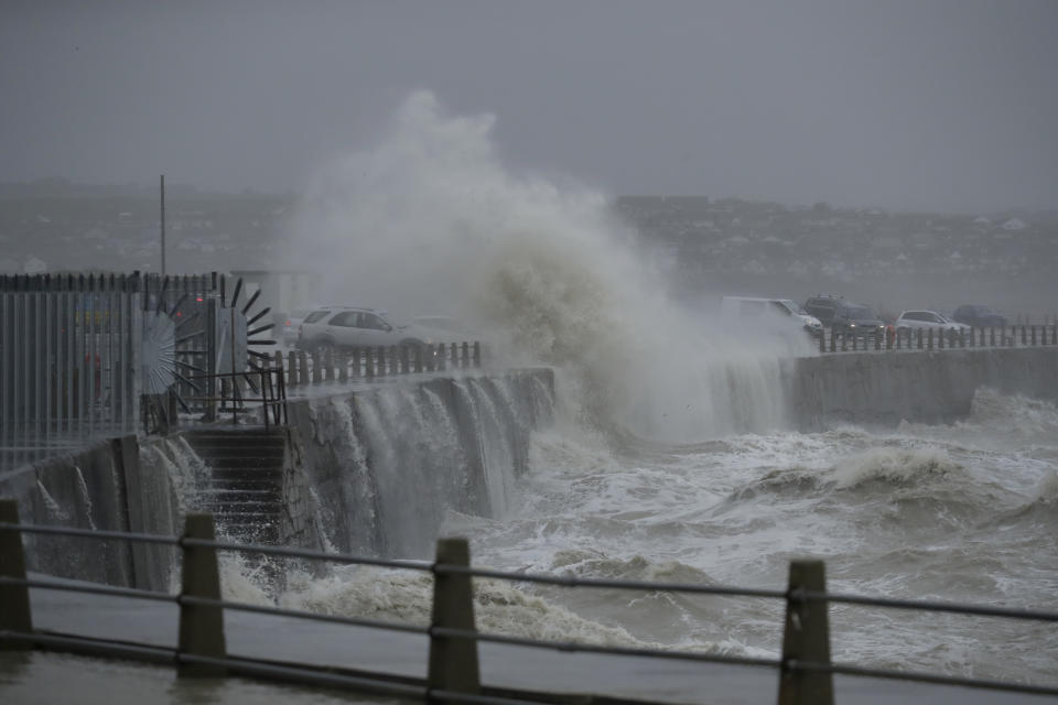 A wave crashes over the sea wall onto cars, as Storm Ciara hits Newhaven, on the south coast of England, Sunday, Feb. 9, 2020. Trains, flights and ferries have been cancelled and weather warnings issued across the United Kingdom and in northern Europe as the storm with winds expected to reach hurricane levels batters the region. (AP Photo/Matt Dunham)