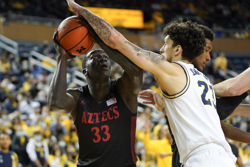 San Diego State forward Aguek Arop (33) drives on Michigan forward Brandon Johns Jr. (23) in the first half of an NCAA college basketball game in Ann Arbor, Mich., Saturday, Dec. 4, 2021. (AP Photo/Paul Sancya)