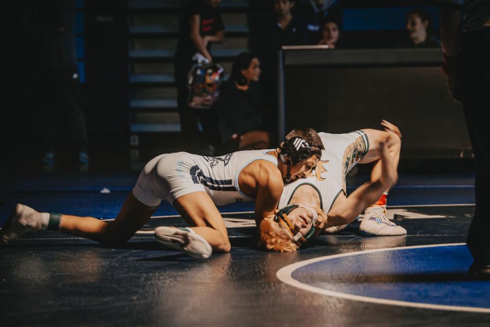 Camarillo's Joshua Requena tries to pin Brody Denham of Royal during the 126-pound final at the Coastal Canyon League wrestling finals on Saturday at Camarillo High. Requena won the title.