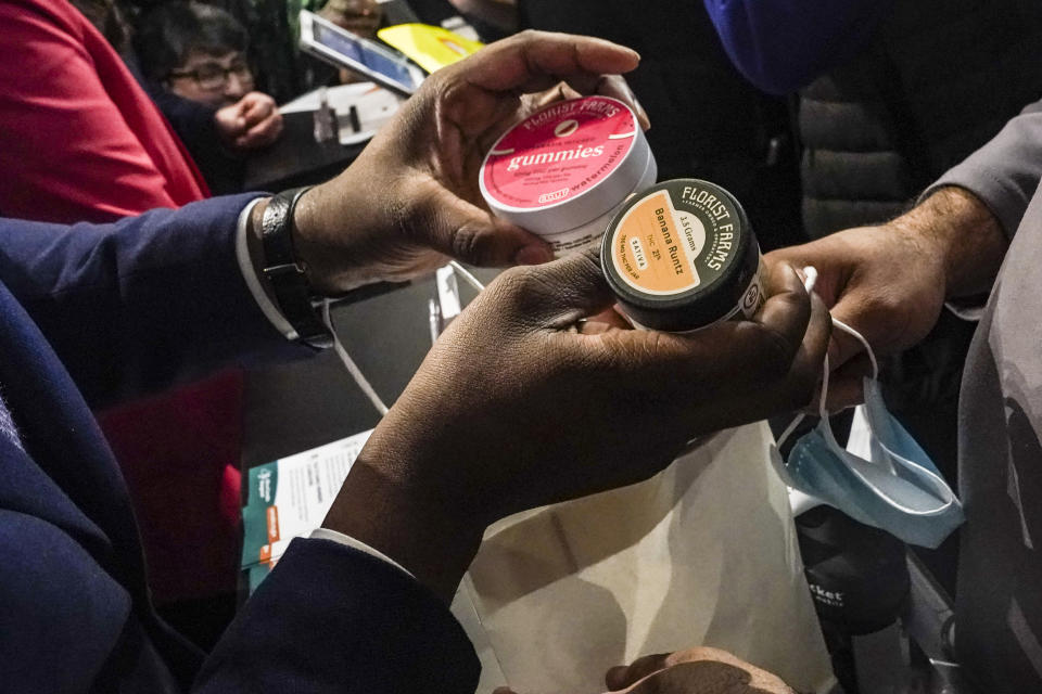 Chris Alexander, executive director of New York State Office of Cannabis Management, bags the first purchase of cannabis products made at Housing Works, New York's first legal cannabis dispensary, during a press conference to kick-off the its opening, Thursday Dec. 29, 2022, in New York. Housing Works, a minority-controlled nonprofit serving people with HIV and AIDS, as well as homeless and formerly incarcerated people, will be the first of 36 recently licensed dispensaries to begin selling cannabis to the general public. (AP Photo/Bebeto Matthews)