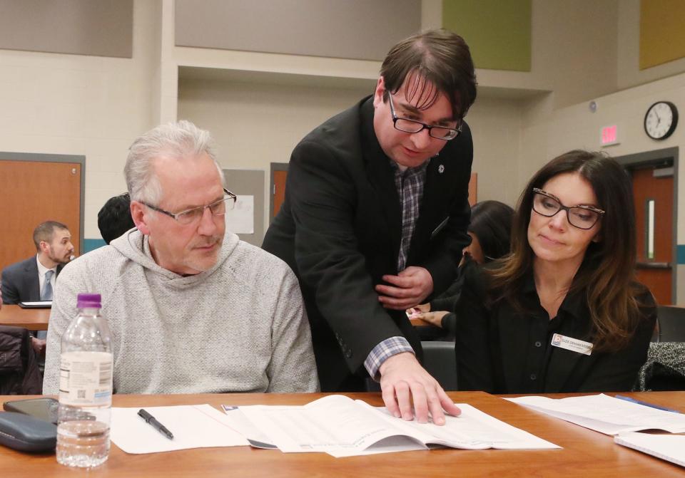 Akron resident Tom Freeman listens as Akron Deputy Finance Director Mike Wheeler and Director of Economic Development Suzie Graham explain a budget item in a small group breakout session during a City of Akron 2024 Operating Budget Town Hall Wednesday night at Firestone High School.
