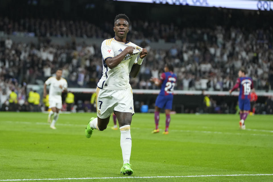 Real Madrid's Vinicius Junior celebrates after scoring his side's opening goal during the Spanish La Liga soccer match between Real Madrid and Barcelona at the Santiago Bernabeu stadium in Madrid, Spain, Sunday, April 21, 2024. (AP Photo/Manu Fernandez)