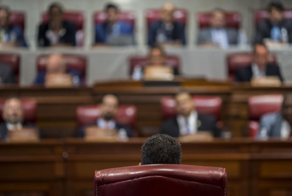 Proposed Secretary of State Pedro Pierluisi (back to camera) speaks during his confirmation hearing at the House of Representatives, in San Juan, Puerto Rico, Friday, August 2, 2019. As Gov. Ricardo Rossello is expected to leave office in a few hours, the Puerto Rican House of Representatives is expected to vote on Pierluisi's confirmation Friday afternoon. If he is rejected, Justice Secretary Wanda Vazquez automatically becomes governor as the next in the order of succession, even though she has said she would unwillingly accept the job. (AP Photo/Dennis M. Rivera Pichardo)