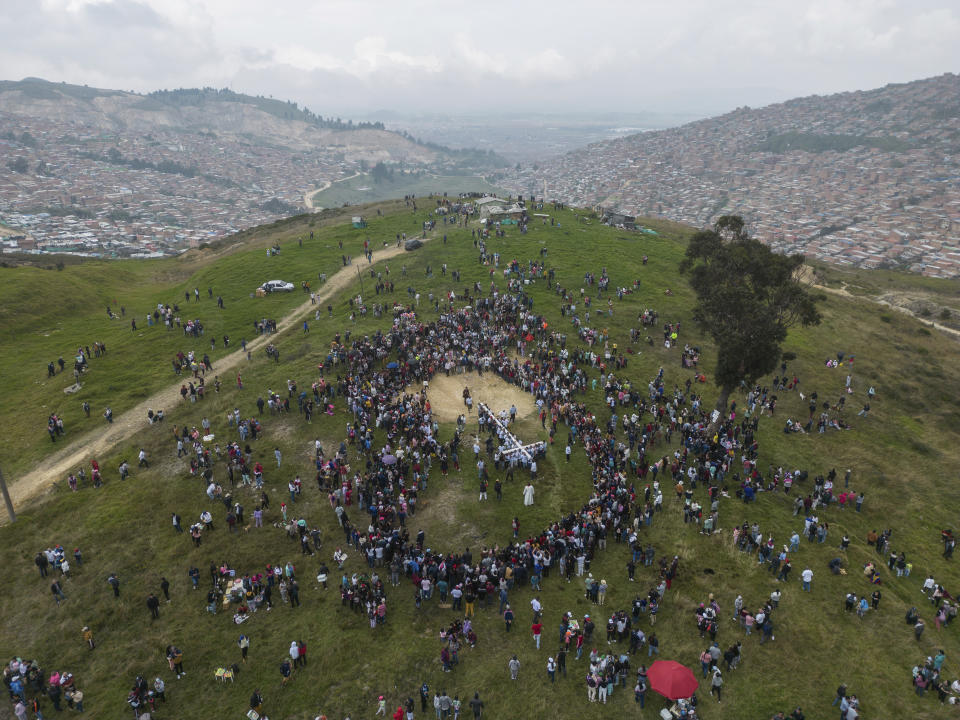 Faithful carry a cross to the Árbol de la Vida or Tree of Life during a Good Friday procession in the hills of the Ciudad Bolivar neighborhood of Bogota, Colombia, Friday, April 7, 2023. Holy Week commemorates the last week of the earthly life of Jesus Christ culminating in his crucifixion on Good Friday and his resurrection on Easter Sunday. (AP Photo/Ivan Valencia)