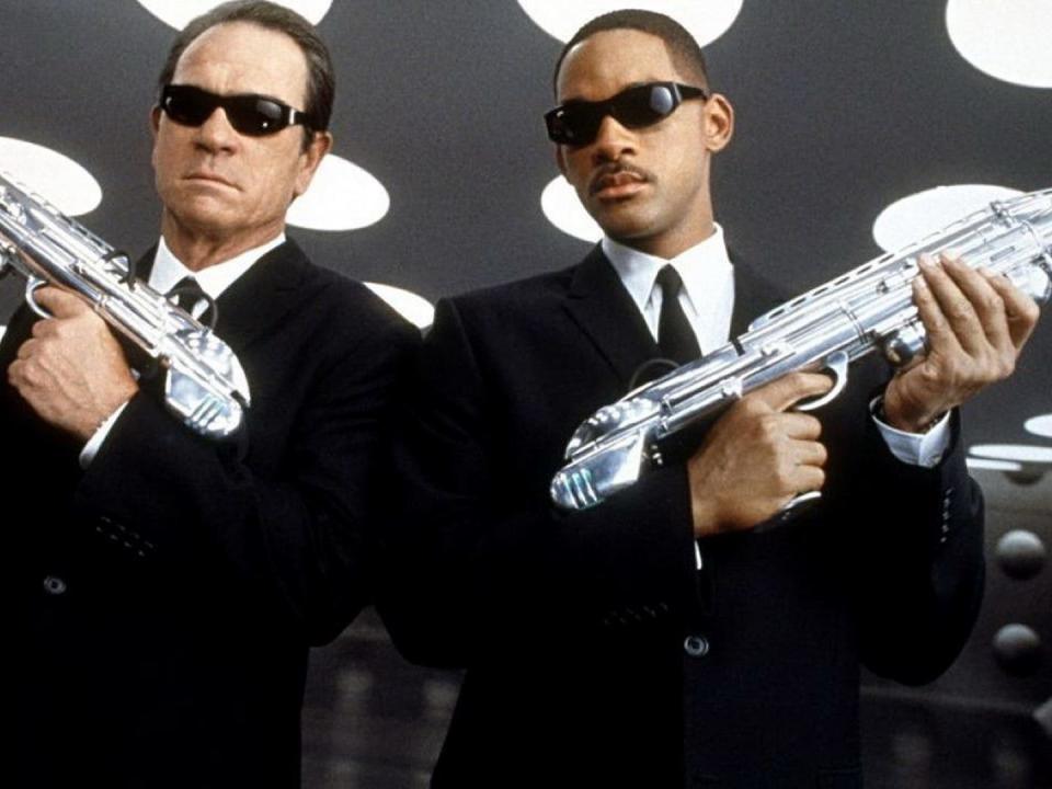 Tommy Lee Jones and Will Smith in "Men in Black" holding futuristic guns