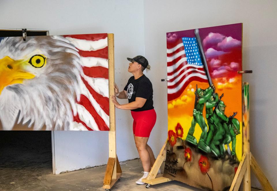 Volunteer Liz Alvarez moves murals into a separate room to prepare for painting in the soon-to-be gallery space for Music Changing Lives in Thousand Palms, Calif., Thursday, Sept. 22, 2022. 