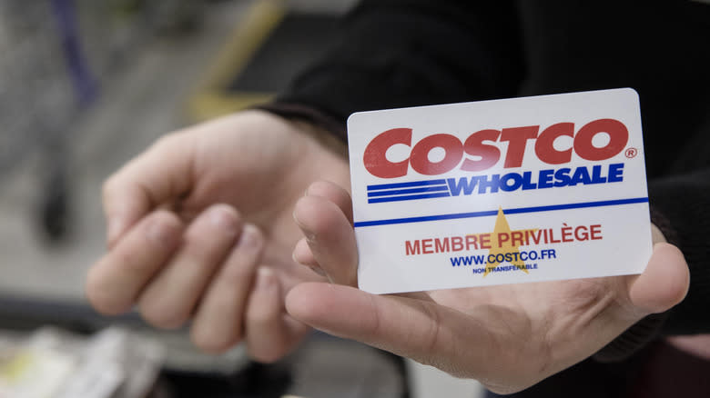 hands holding costco membership card