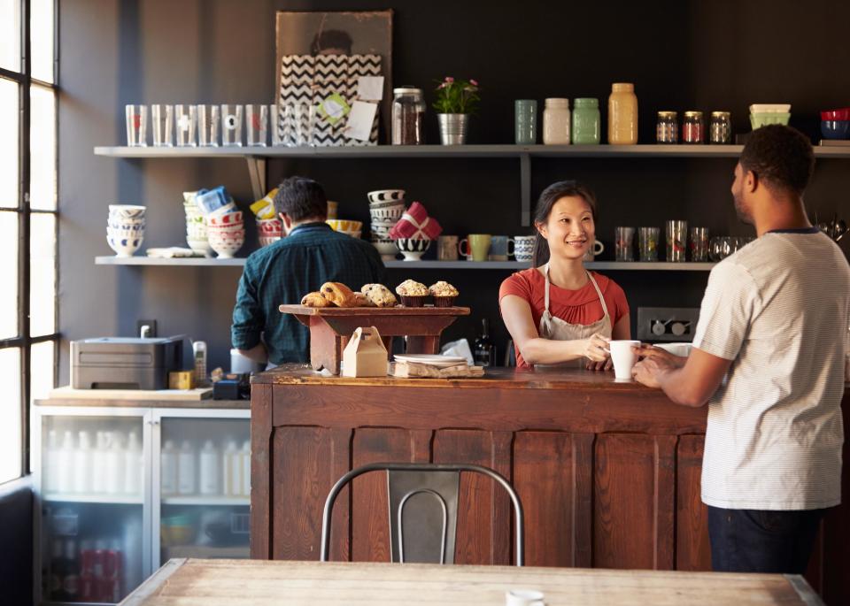 Staff serving a customer in a busy coffee shop.