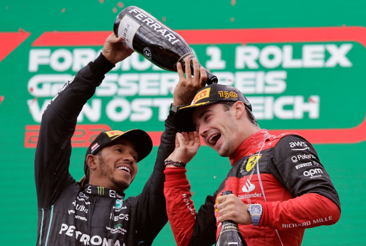 Ferrari’s Charles Leclerc celebrates on the podium with Mercedes’ Lewis Hamilton after the Austrian Grand Prix  (Reuters)