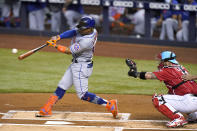 New York Mets' Francisco Lindor hits a double next to Miami Marlins catcher Sandy Leon durning the first inning of a baseball game Friday, May 21, 2021, in Miami. (AP Photo/Lynne Sladky)