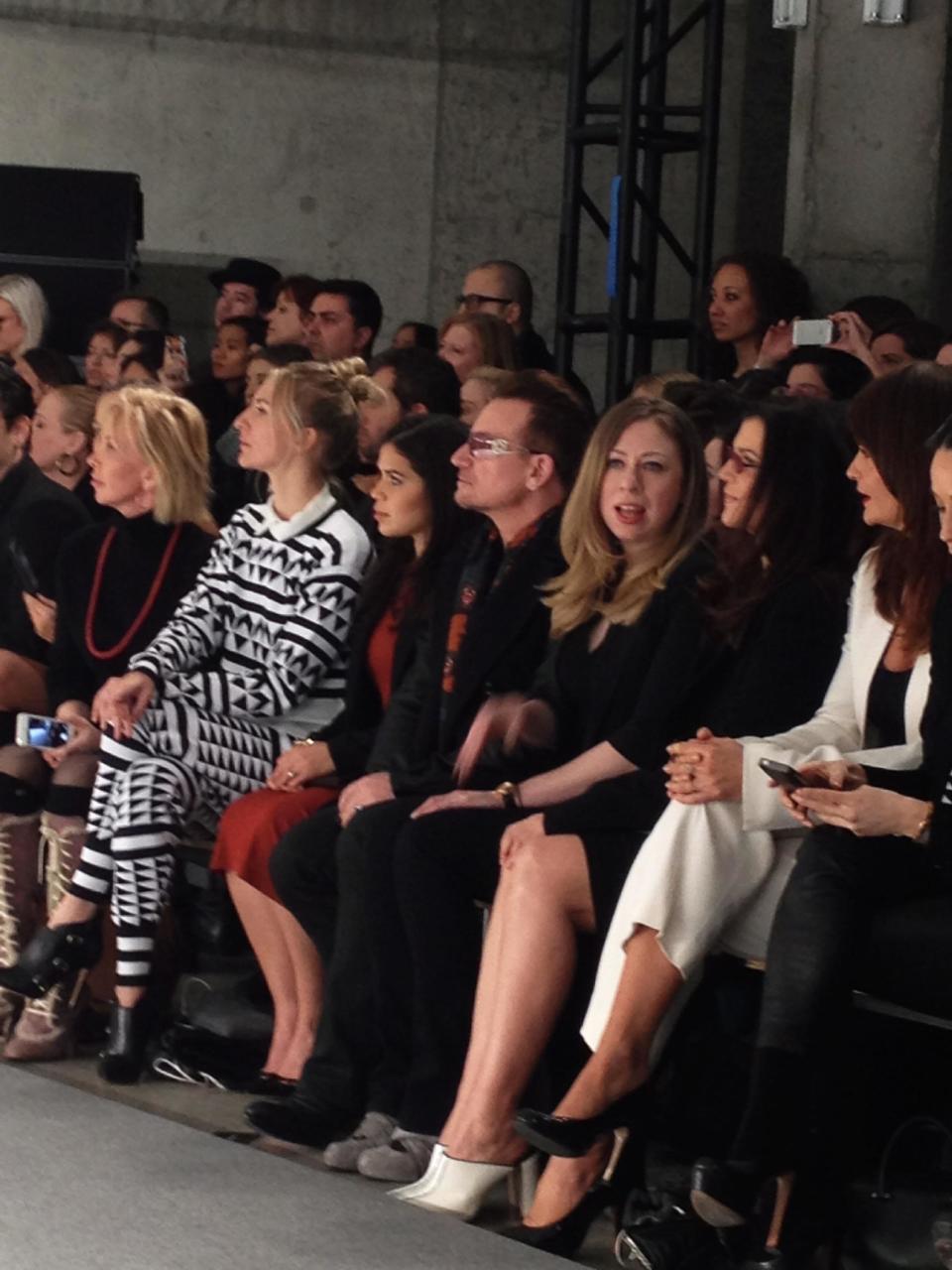 Chelsea Clinton sits in between singer Bono and his wife Ali Hewson, co-founders of the Edun line, in the front row of the Edun runway show during New York Fashion Week, Sunday Feb. 9, 2014, in New York. (AP Photo/Leanne Italie)