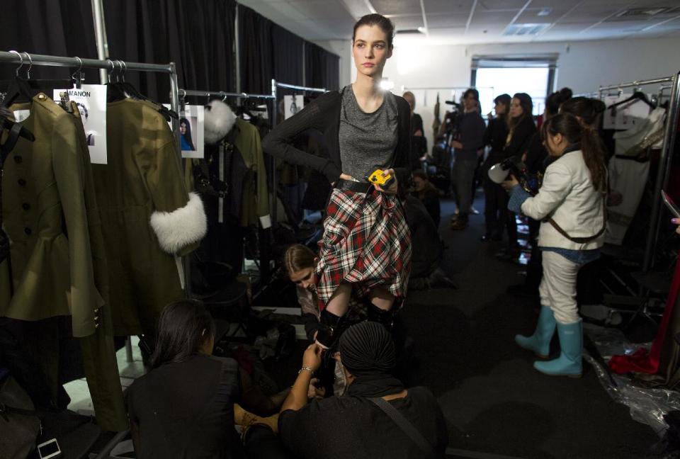 A model is fitted for boots backstage before the presentation of the Prabal Gurung Fall 2013 fashion collection during Fashion Week, Saturday, Feb. 9, 2013, in New York. (AP Photo/Craig Ruttle)