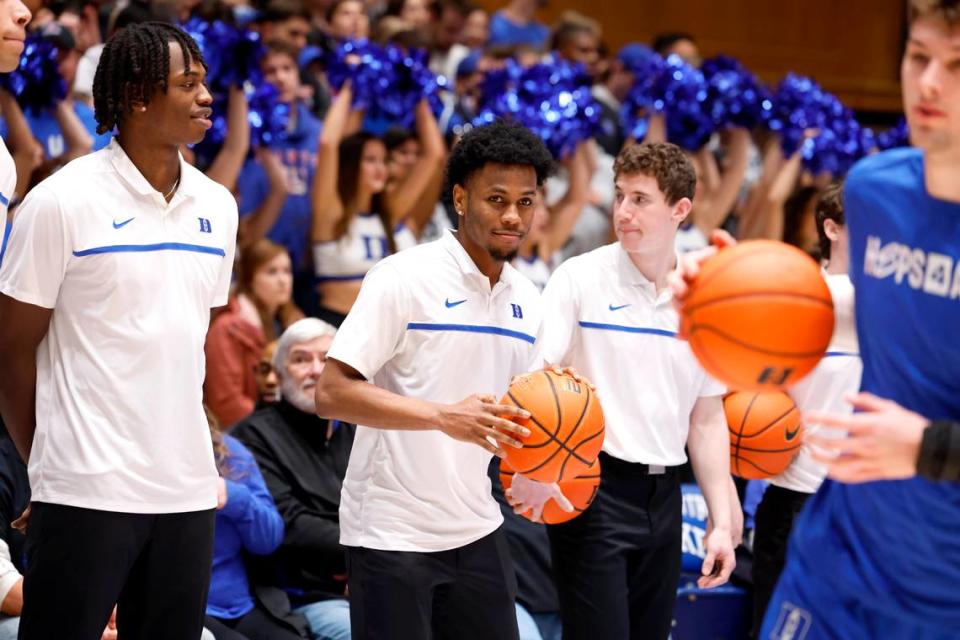 Duke’s Mark Mitchell, left, and Jeremy Roach watch the team warmup before Duke’s game against Pitt at Cameron Indoor Stadium in Durham, N.C., Saturday, Jan. 20, 2024.