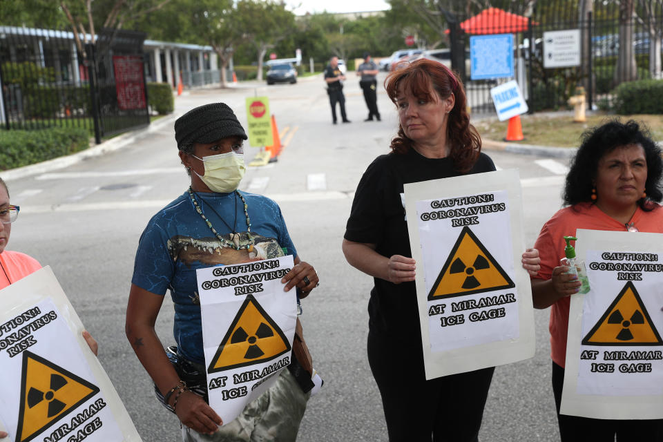 Odalys K. Fernandez, Laurie Woodward Garcia and Yaquelin Lopez protest outside an ICE office in Miramar, Fla.