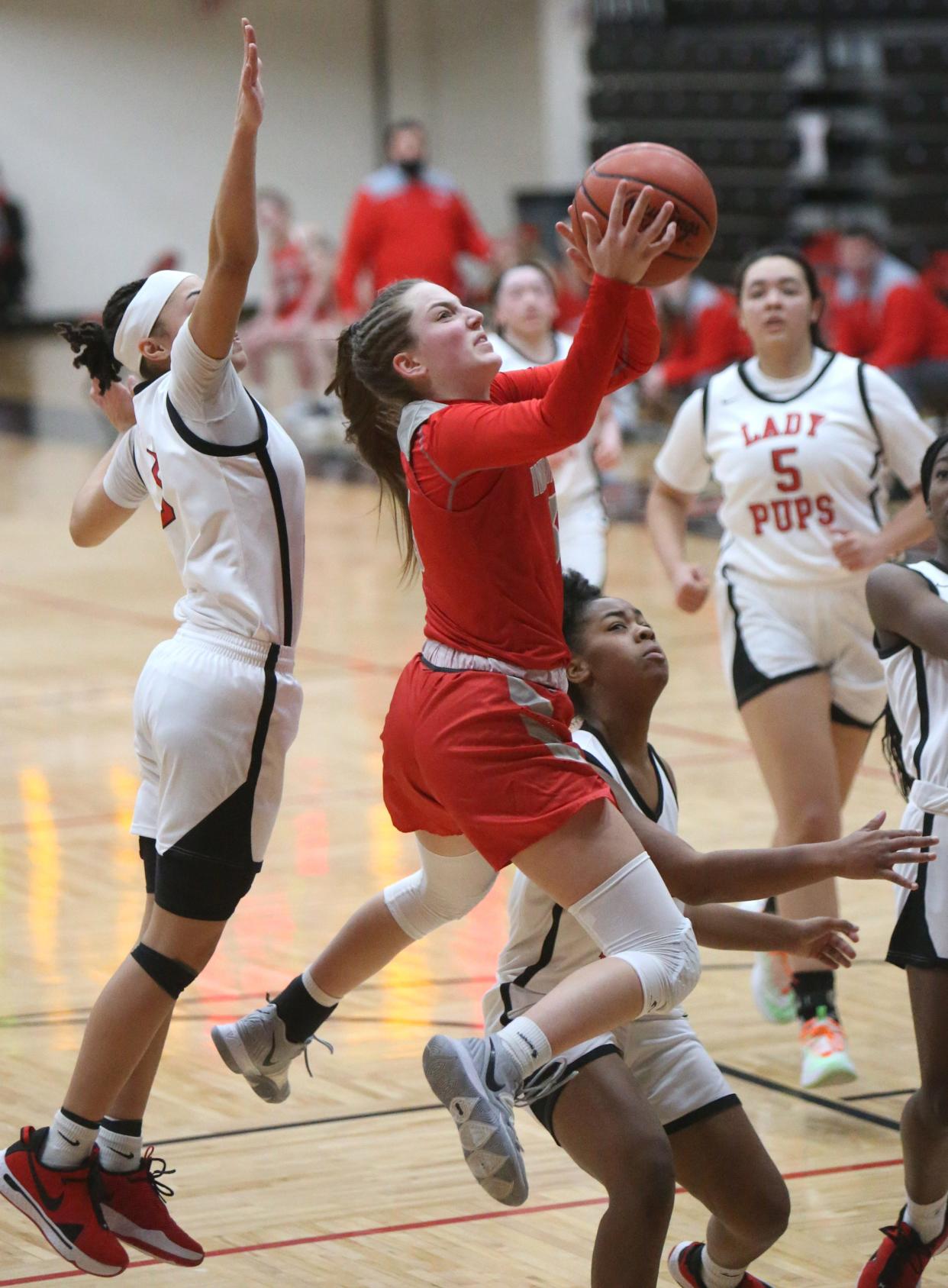 Ashley Cudnik (center) of Northwest drives to the basket between Nakyah Terrell (left) and Nataijah Davis (right) of McKinley during a game last season.