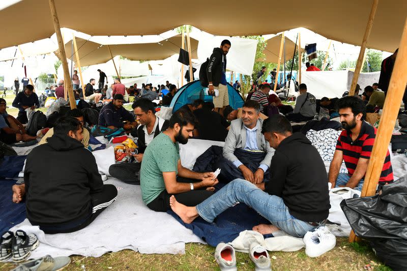 Refugees wait outside at the main reception centre for asylum seekers, in Ter Apel