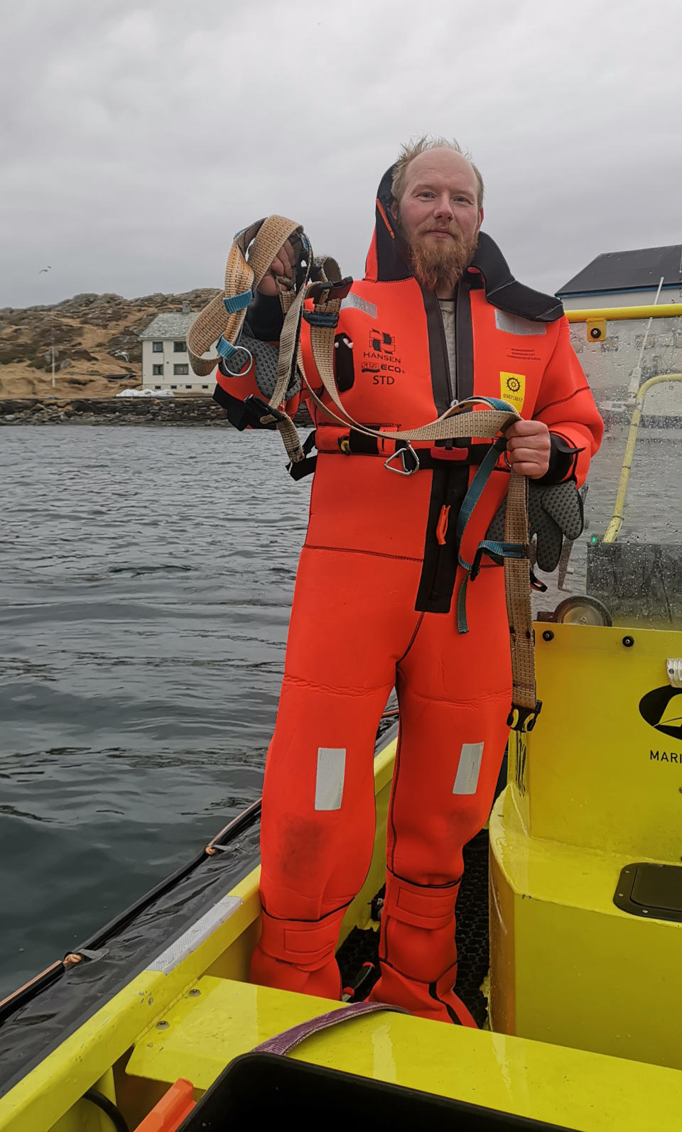 Norwegian Joergen Ree Wiig holds the whale harness after it was removed from a beluga whale off the northern Norwegian coast Friday, April 26, 2019.  The harness strap which features a mount for an action camera, says "Equipment St. Petersburg" which has prompted speculation that the animal may have escaped from a Russian military facility. (Joergen Ree Wiig/Norwegian Direcorate of Fisheries Sea Surveillance Unit via AP)