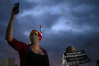 People march along Las Americas Highway to protest the LUMA Energy company in San Juan, Puerto Rico, Friday, Oct. 15, 2021. Ever since LUMA began providing service over the summer, hundreds of thousands of Puerto Ricans have had to deal with widespread blackouts for extended periods of time, voltage fluctuations and bad customer service along with an increase in pricing. (AP Photo/Carlos Giusti)