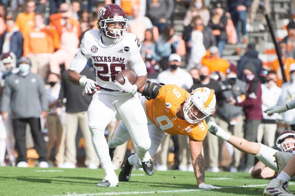 Texas A&M running back Isaiah Spiller runs the ball while defended by Tennessee linebacker Tyler Baron (9) during their game at Neyland Stadium in Knoxville, Tenn.
