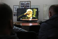 FILE - In this Wednesday, Nov. 29, 2017 file photo, Bosnian people watch the live TV broadcast from the International Criminal Court for the former Yugoslavia (ICTY) in The Hague as Slobodan Praljak brings a bottle to his lips, in southern Bosnian town of Mostar 140 kms south of Sarajevo. Julian Assange relayed how he “binge-watched” the suicide of the former Bosnian Croat general in a United Nations courtroom three years ago, a doctor who visited the WikiLeaks founder on several occasions while he was in the Ecuadorian Embassy in London told an extradition hearing Thursday, Sept, 24, 2020. (AP Photo/Amel Emric, file)