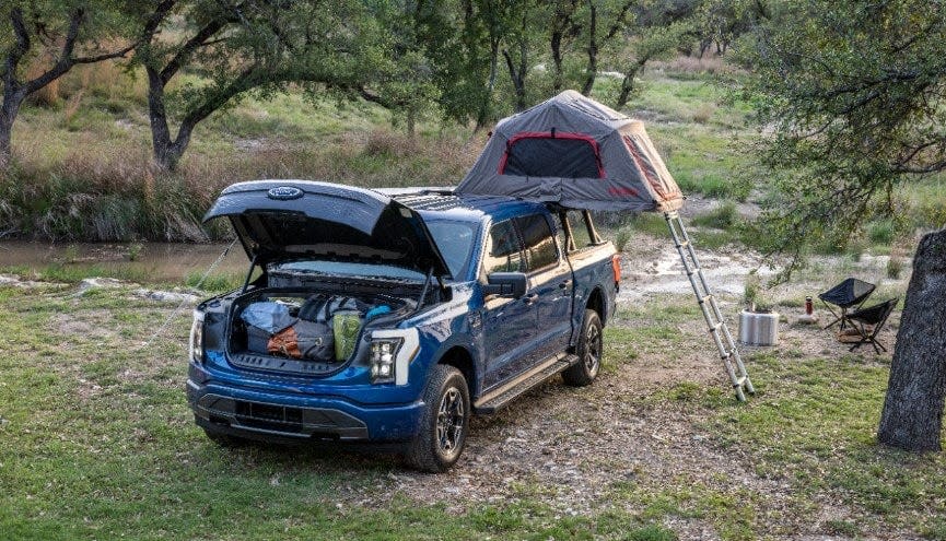 The 2022 Ford F-150 Lightning XLT is used for camping by new pickup truck owners attracted by the idea of driving an electric vehicle. The front trunk adds extra space because there's no engine. A battery is attached to the underbelly of the vehicle.