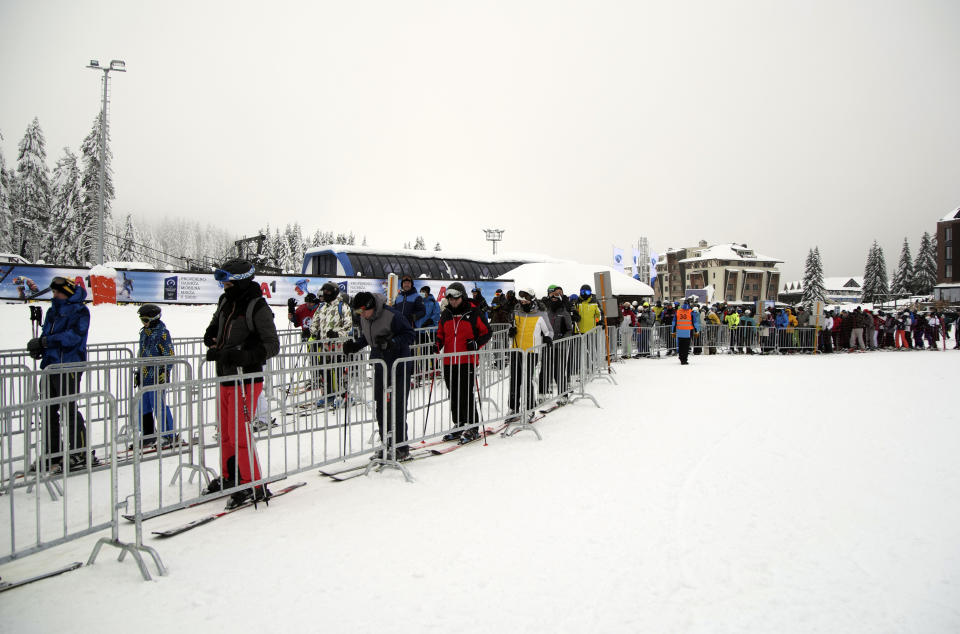 Skiers wait in a lift queue on Mount Kopaonik, Serbia, Thursday, Dec. 9, 2021. As most of Europe reintroduces measures to help curb the spread of the omicron variant, Bosnia, to the delight of its winter tourism industry, still maintains a relatively laissez-fair approach to the soaring COVID-19 infection numbers across the continent. (AP Photo/Marjan Vucetic)