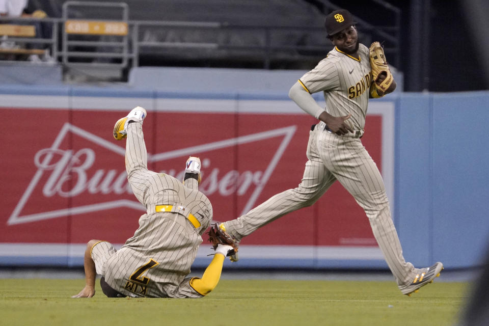 San Diego Padres shortstop Ha-Seong Kim tumbles after making a catch on a ball hit by Los Angeles Dodgers' Mookie Betts as left fielder Jurickson Profar watches during the fifth inning of a baseball game Friday, Sept. 2, 2022, in Los Angeles. (AP Photo/Mark J. Terrill)