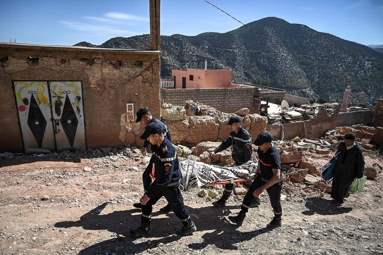 Los bomberos trasladan uno de los miles de cuerpos encontrados entre los escombros