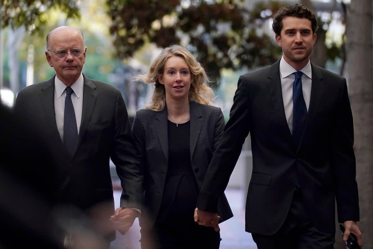 Former Theranos CEO Elizabeth Holmes, center, arrives at federal court with her father, Christian Holmes IV, at trial in 2022. (Associated Press)