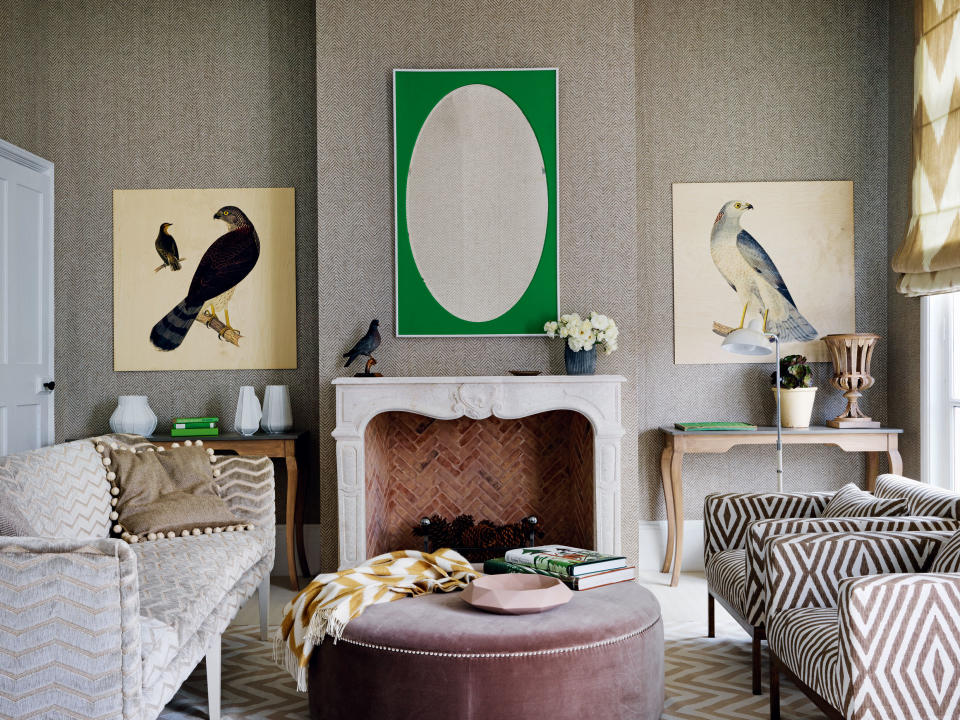 Textured wallaper ideas in a taupe living room, with green and white accents, geometric print chairs and a stone fireplace.