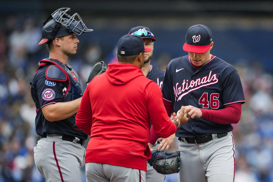 Washington Nationals starting pitcher Patrick Corbin (46) gives the ball to manager Dave Martinez during the sixth inning of the team's baseball game against the Toronto Blue Jays in Toronto on Wednesday, Aug. 30, 2023. (Andrew Lahodynskyj/The Canadian Press via AP)