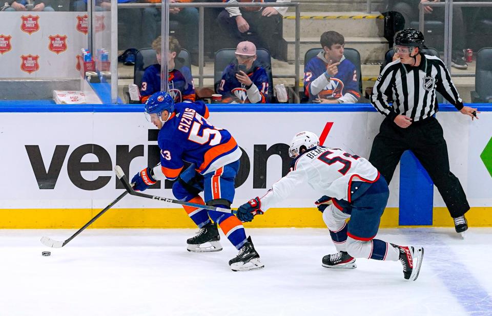 New York Islanders center Casey Cizikas (53) is defended by Columbus Blue Jackets right wing Emil Bemstrom (52) during the first period of an NHL hockey game in Elmont, N.Y., Thursday, Dec. 7, 2023. (AP Photo/Peter K. Afriyie)