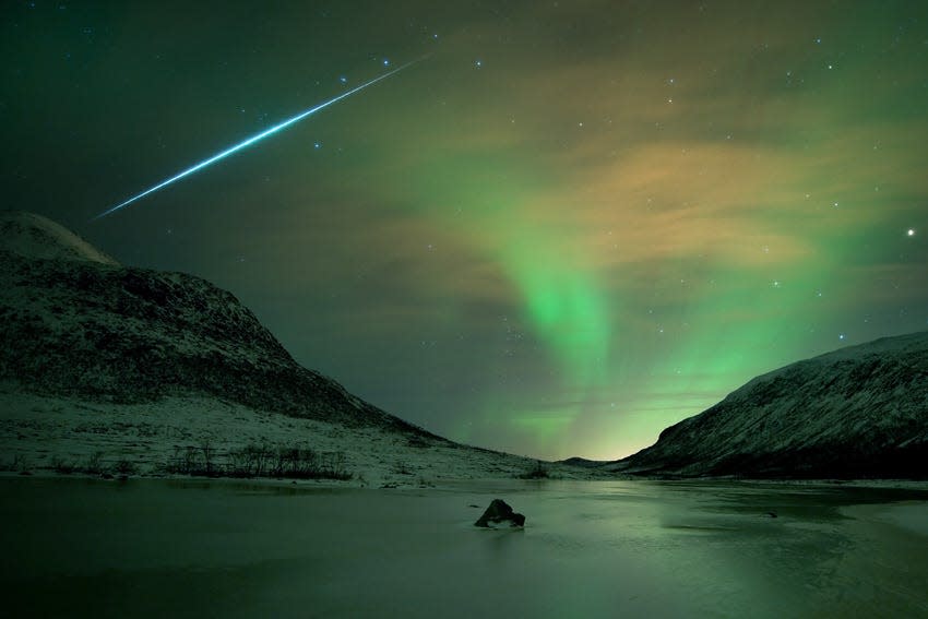 A 30 second exposure captures the sudden flash of a fireball meteor from the Geminids amid the shimmering glow of the Northern Lights, or aurora borealis, last December in Norway.