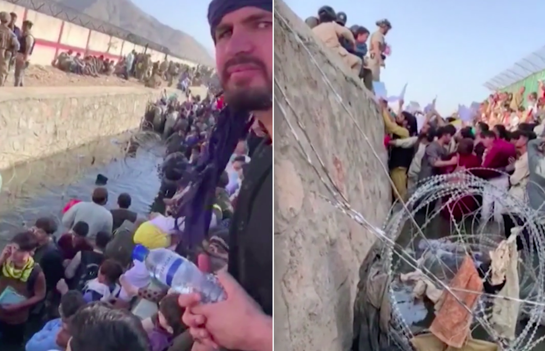 Afghans wade in water and between barbed wire as they wait outside Kabul airport.