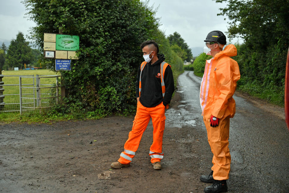 Contractors in PPE, waiting to go onsite, outside Rook Row Farm in Mathon, near Malvern, Herefordshire, where there have been 73 positive cases of coronavirus confirmed.