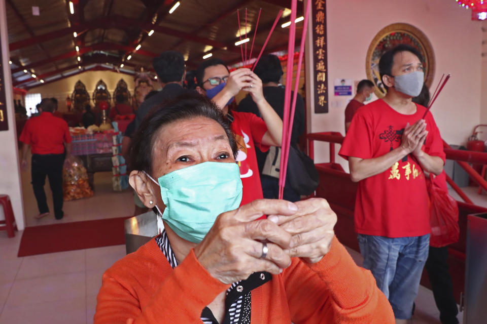 Ethnic Chinese worshippers wearing face masks to help curb the spread of coronavirus outbreak pray during the Lunar New Year celebrations at a temple in the China Town area of Jakarta, Indonesia, Friday, Feb.12, 2021. (AP Photo/Tatan Syuflana)