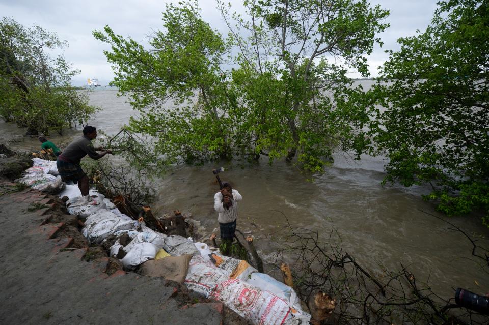 Villagers reinforce an embankment with sacks of soil ahead of the expected landfall of cyclone Amphan, in Dacope on May 20, 2020. - Several million people were taking shelter and praying for the best on Wednesday as the Bay of Bengal's fiercest cyclone in decades roared towards Bangladesh and eastern India, with forecasts of a potentially devastating and deadly storm surge. Authorities have scrambled to evacuate low lying areas in the path of Amphan, which is only the second "super cyclone" to form in the northeastern Indian Ocean since records began. (Photo by Munir Uz zaman / AFP) (Photo by MUNIR UZ ZAMAN/AFP via Getty Images)