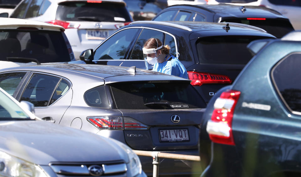People are seen at a Covid Testing Centre at Indooroopilly High School Brisbane , Sunday, August 1, 2021. Queensland has gone into a snap three-day lockdown after six locally-acquired cases of COVID-19, reported on Saturday, were linked to an Indooroopilly High School student. (AAP Image/Jason O'Brien) NO ARCHIVING