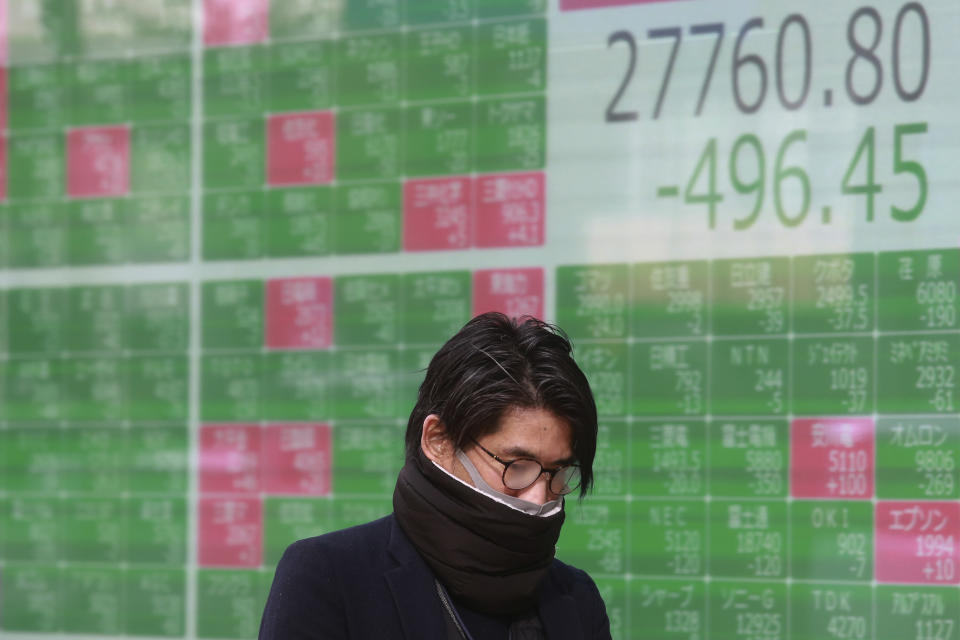 A man walks by an electronic stock board of a securities firm in Tokyo, Wednesday, Jan. 19, 2022. Asian shares were lower Wednesday after a retreat on Wall Street. (AP Photo/Koji Sasahara)