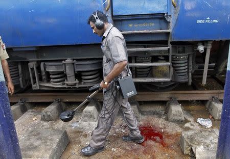 A member of the bomb disposal squad examines the area next to a passenger train in which two explosions occurred, at the railway station in Chennai May 1, 2014. REUTERS/Babu