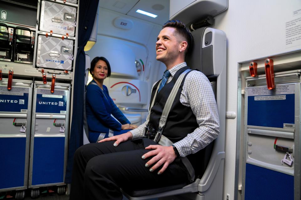 Flight attendant Ryan Briggs on board a United flight. All United Airlines flight attendants will now be able to wear colorful nail polish.