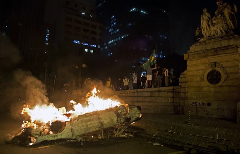 A car set on fire by demonstrators burns in front of the state assembly building in Rio de Janeiro on June 17, 2013. Sports Minister Aldo Rebelo warned that authorities would not allow the protests to disrupt international football tournaments in Brazil