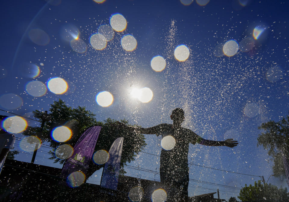 FILE - A youth cools off at the "Parque de Agua" public water park on a hot summer day in Santiago, Chile, Jan. 31, 2024. For the eighth straight month, Earth was record hot, according to the European climate agency’s analysis of January 2024. (AP Photo/Esteban Felix, File)