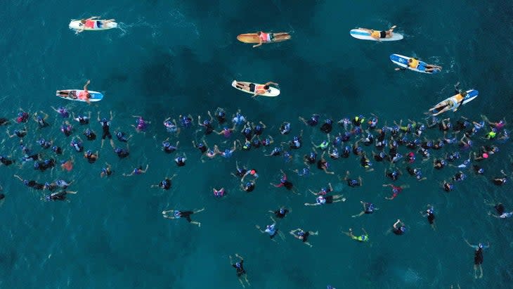 A bunch of swimmers wait in water from above